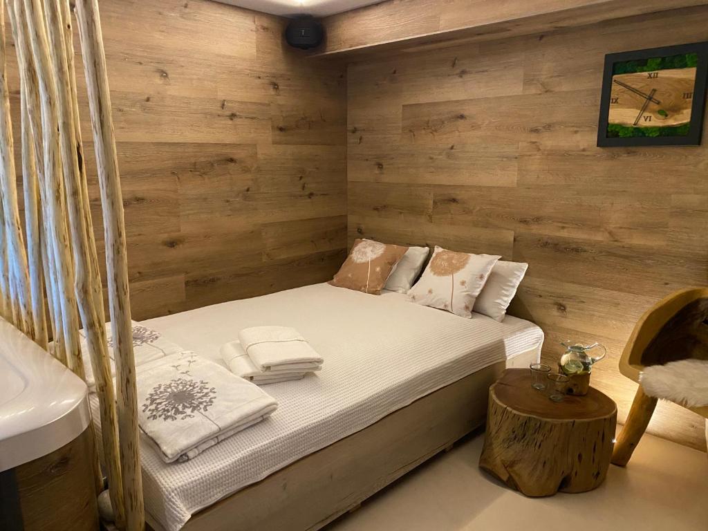 um pequeno quarto com uma cama e um lavatório em Apartmány & Wellness Revenite em Jeseník