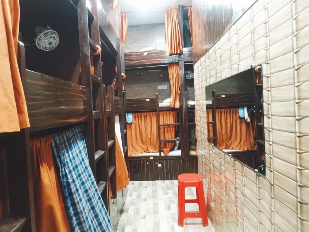 a small room with a red stool in a bus at Kalina Asian Dormitory in Mumbai