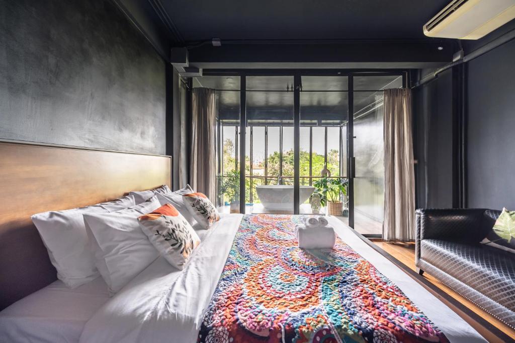 1 dormitorio con 1 cama con ordenador portátil en MIQ Ekkamai2 3BR Designer home Oval Bathtub 15pax en Bangkok