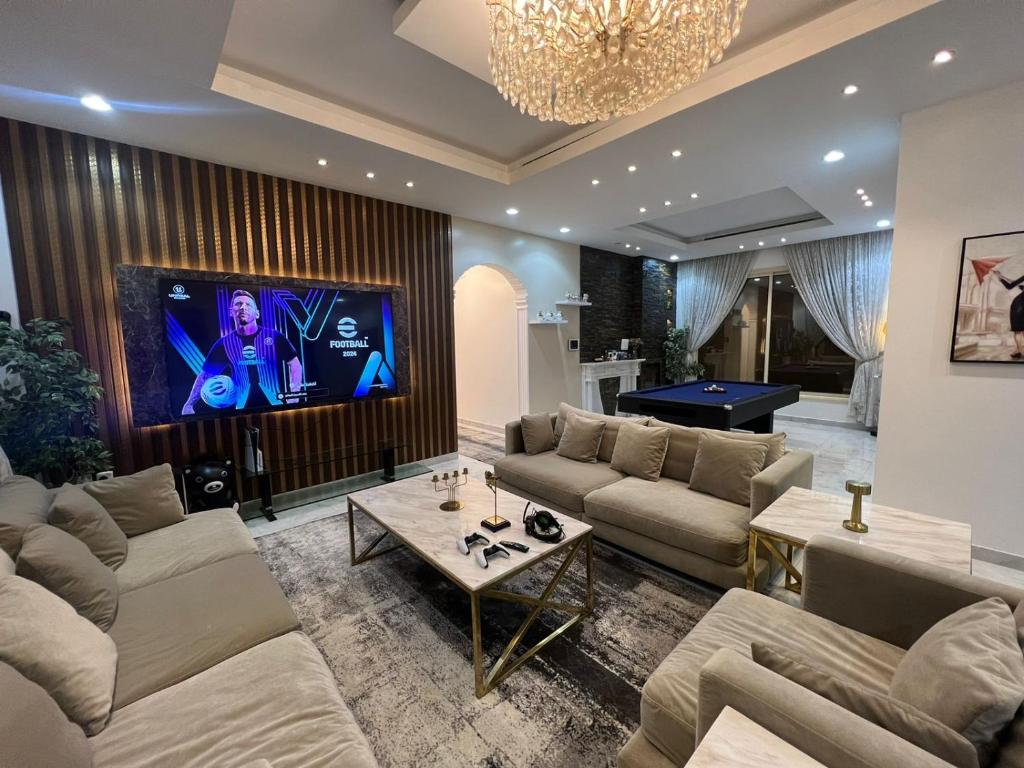 بيت النرجس الخاص في الرياض: غرفة معيشة مع كنب وطاولة بلياردو