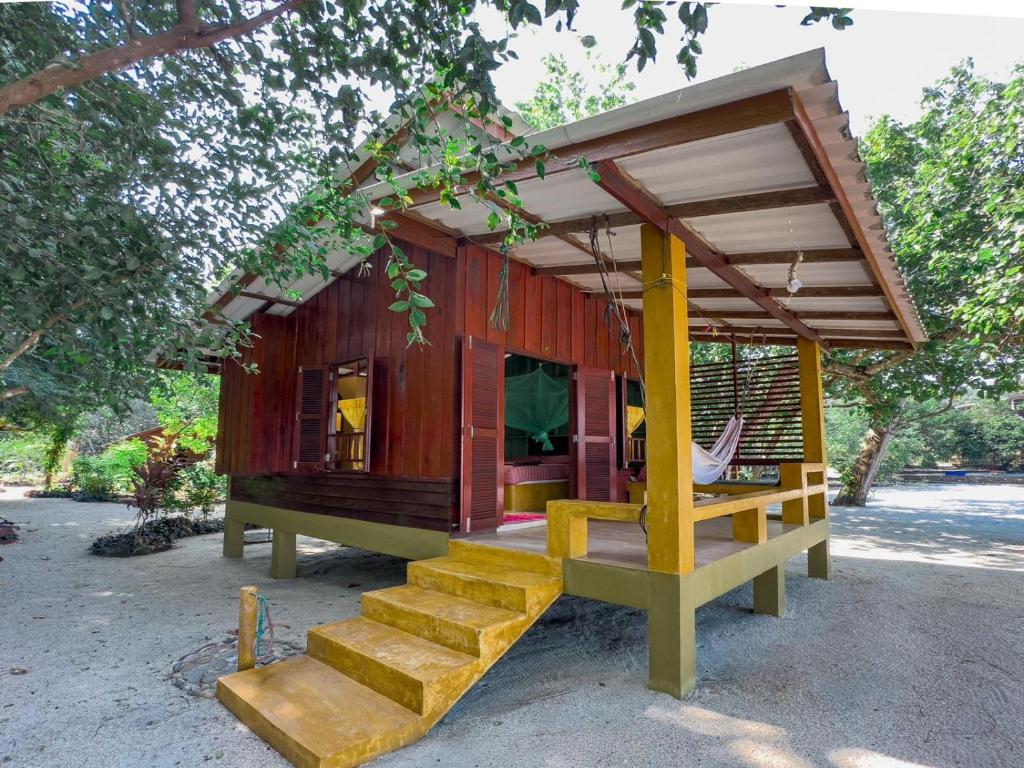 una pequeña casa de madera con escaleras en un patio en Sawasdee Resort, en Koh Chang