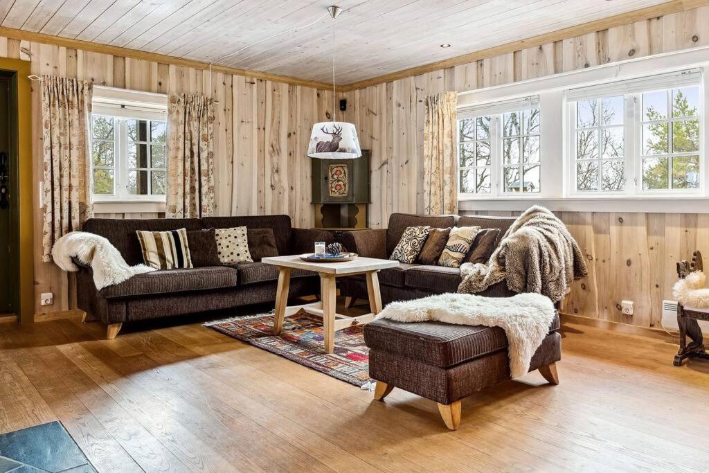a living room with a couch and a table at Koslig hytte ved Grimsdalen in Dovre