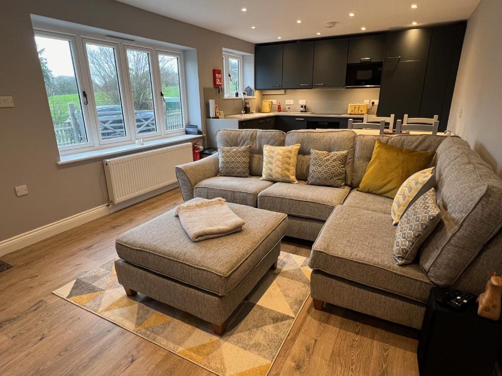 a living room with two couches and a kitchen at Shepherd's Cottage in Totland