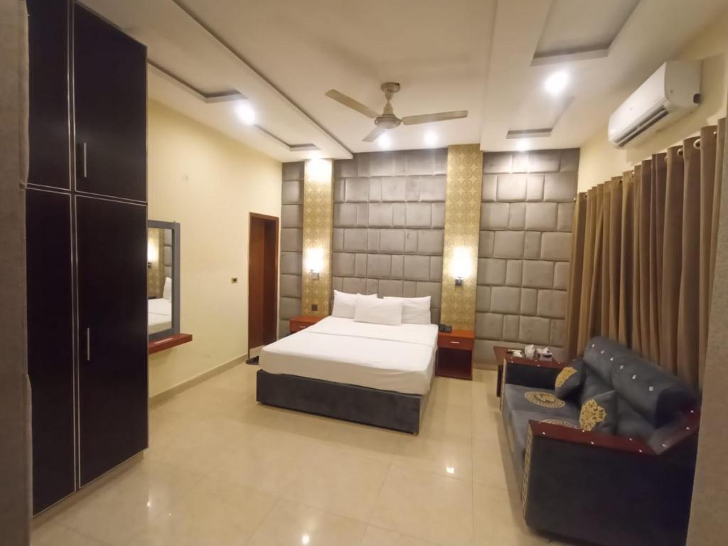 a hotel room with a bed and a couch at R.M RESIDENCY in Lahore