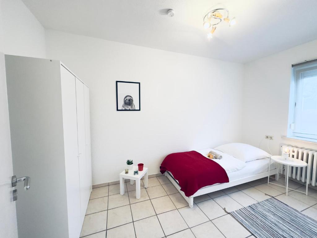 a white bedroom with a bed and a table at Möbliert-Ruhige Lage- W-LAN -Netflix-Herne in Herne