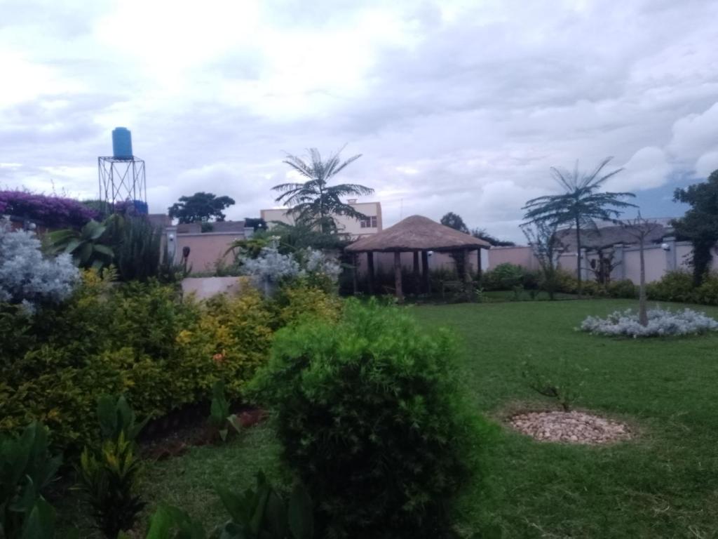 a garden with a gazebo and palm trees at La tendresse in Antananarivo