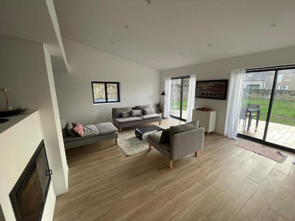 un salon avec des canapés et une télévision à écran plat dans l'établissement Maison rénovée en Bourgogne - Renewed house in Burgundy, à Talcy