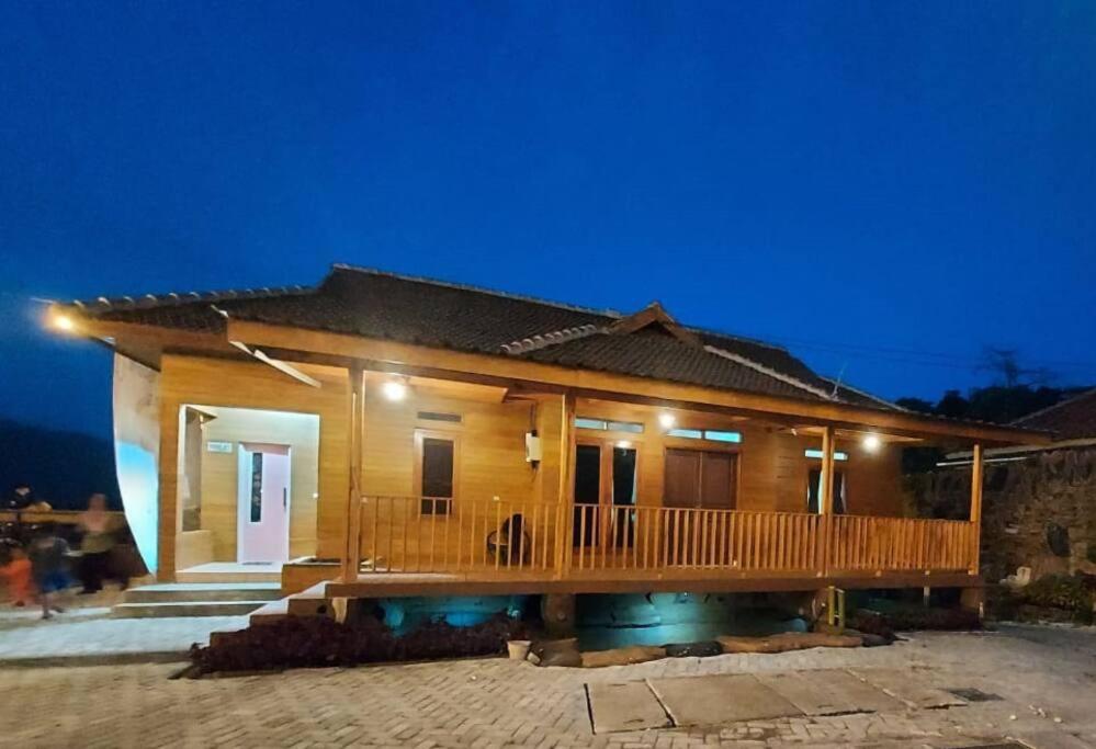 una piccola casa in legno con terrazza di notte di Villa Sari Leueut Suramadu Majalengka 