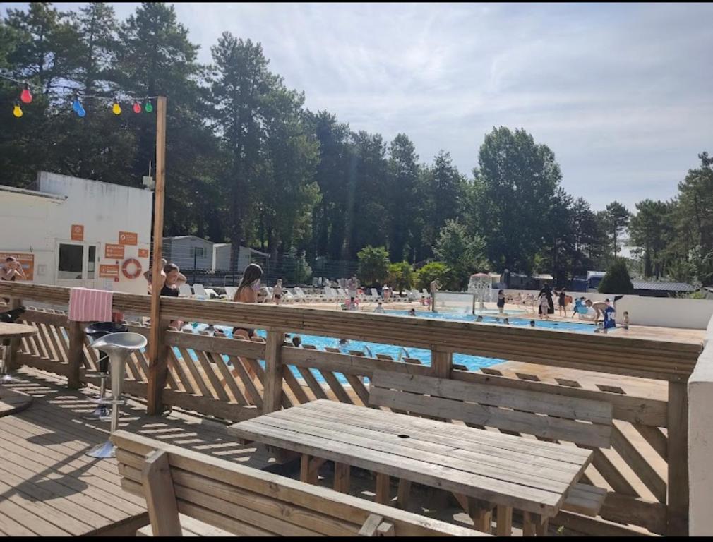 a wooden bench sitting next to a swimming pool at Au petit paradis in Camiers