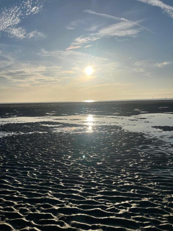 a beach with the sun rising over the water at Au petit paradis in Camiers