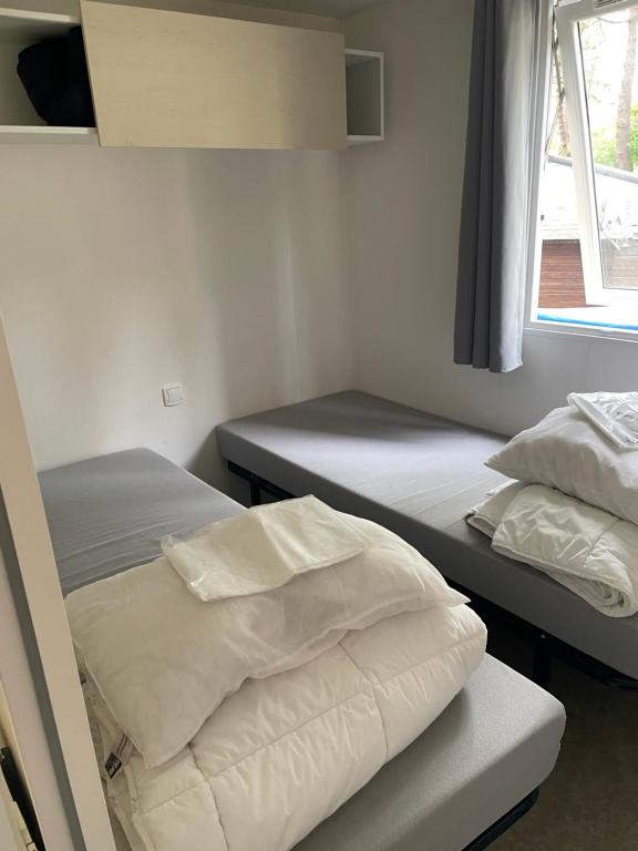a bedroom with two beds and a window at Au petit paradis in Camiers