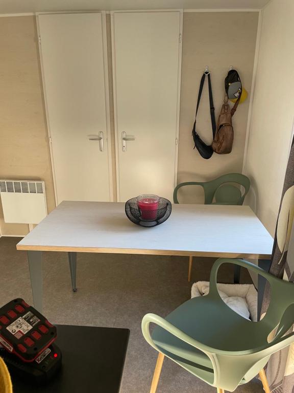 a room with a table and a green chair at Au petit paradis in Camiers