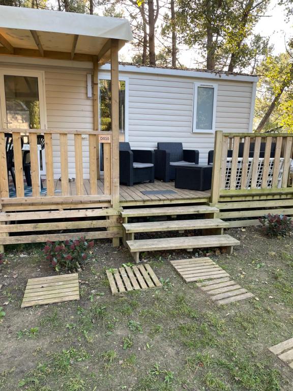 a house with a wooden deck with chairs on it at Au petit paradis in Camiers