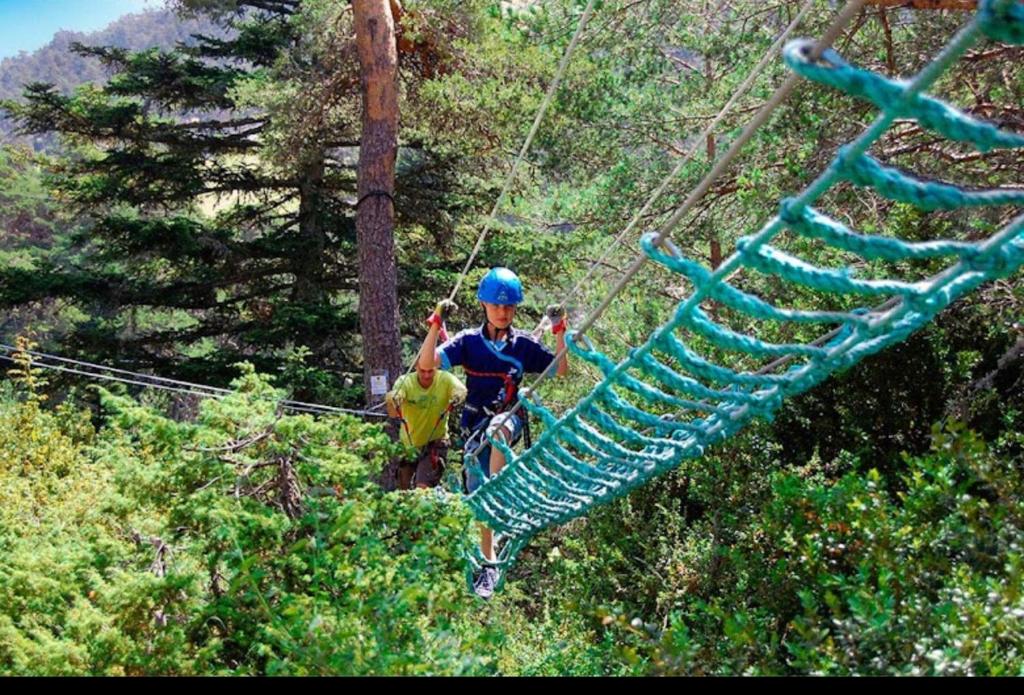 two people on a zip line in the trees at Au petit paradis in Camiers