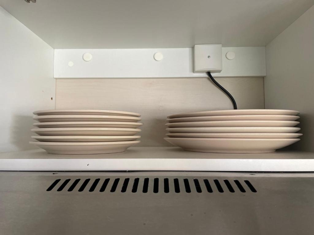 three stacks of plates on a shelf in a kitchen at Au petit paradis in Camiers