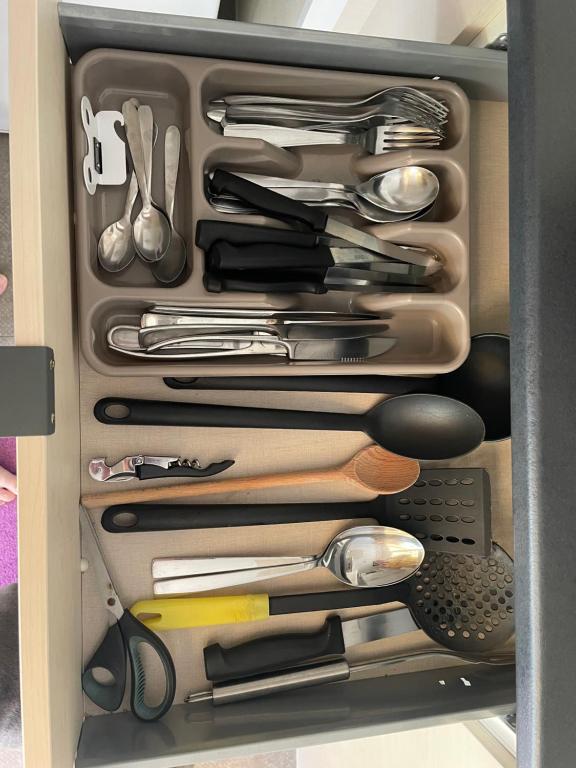 a drawer full of utensils in a cabinet at Au petit paradis in Camiers