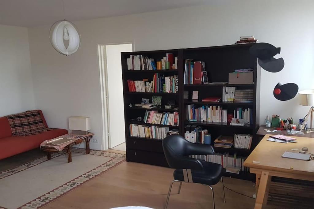 un salon avec une étagère remplie de livres dans l'établissement Appartement spacieux aux portes de Paris, à Bagnolet