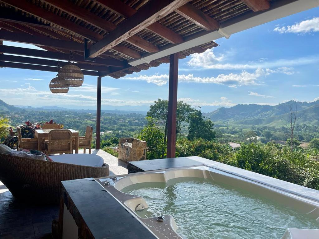 a hot tub on a patio with a view of the mountains at Hotel Spa La Colina in Pereira
