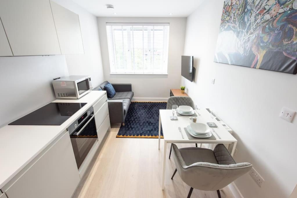 - une petite cuisine blanche avec une petite table et des chaises dans l'établissement Space Apartments -One Bed Apartment In Central Brentwood - Fast Wifi - Parking - 45, à Brentwood