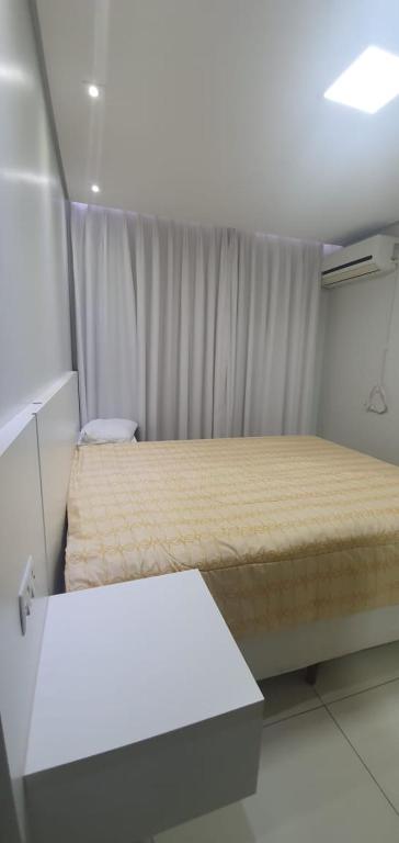 um pequeno quarto com duas camas e uma mesa em Apartamento 410 Castelo de Luxemburgo em Campo Grande