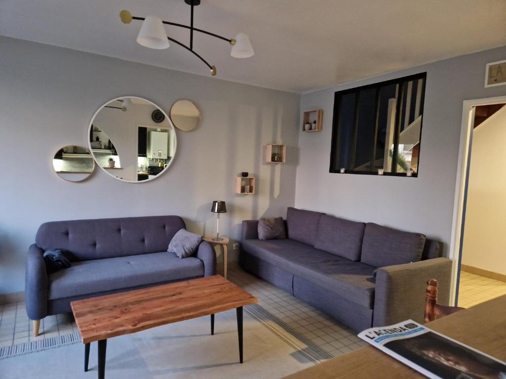 a living room with a couch and a table at Sérénité au cœur de ville in Saint-Dizier