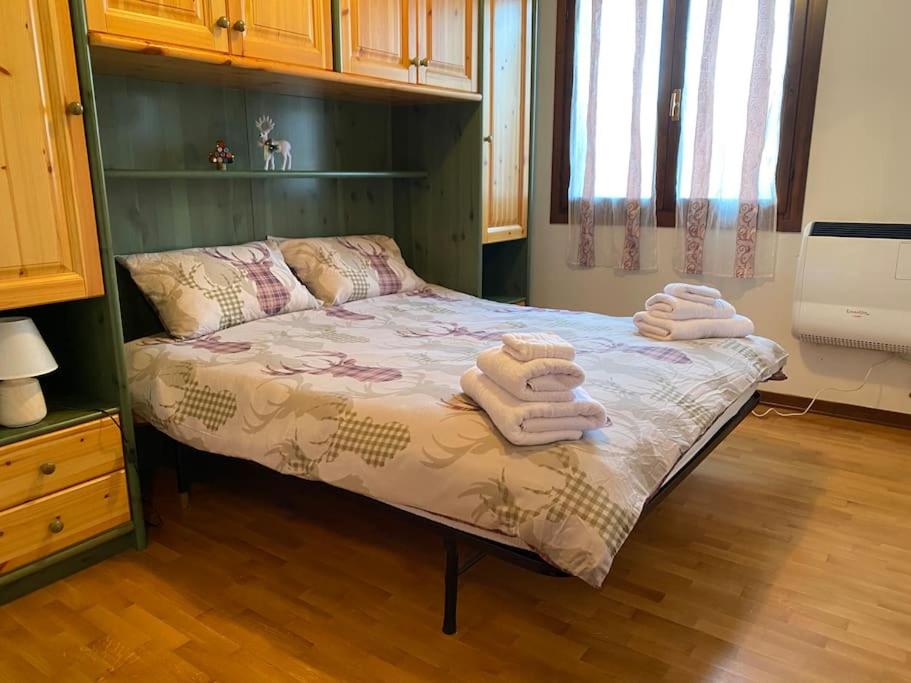 a bedroom with a bed with towels on it at [App. Tremol] 50 mt da piste sci in Piancavallo