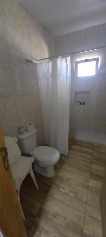 a white bathroom with a toilet and a window at Quinta estilo campo La Calandria in Saladillo