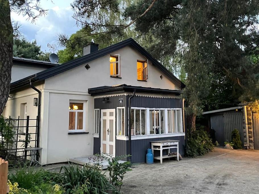 een klein wit huis met twee ramen en een oprit bij Willa Walerianka in Sulejówek