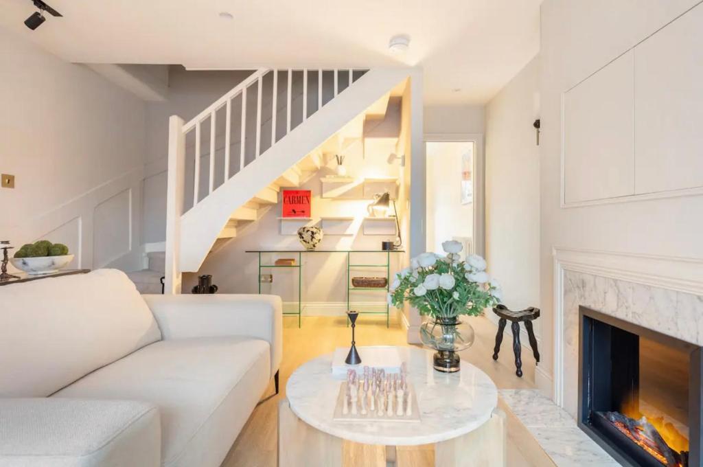 a living room with a white couch and a fireplace at Spring Stays Cosy 2-Bed Residence with Free Parking in London