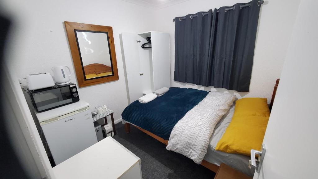 a small bedroom with a bed and a mirror at Cosy and Relaxing in Chatham