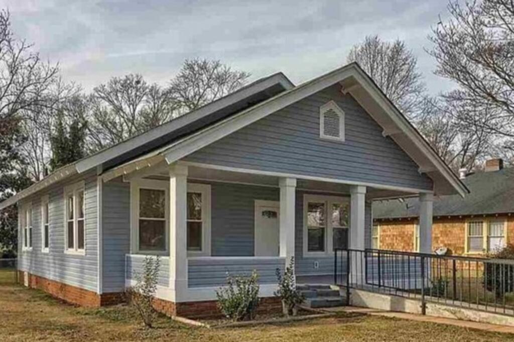 a small blue house with a porch at Cozy Swamp Rabbit - Sans Souci Greenville Furman in Greenville