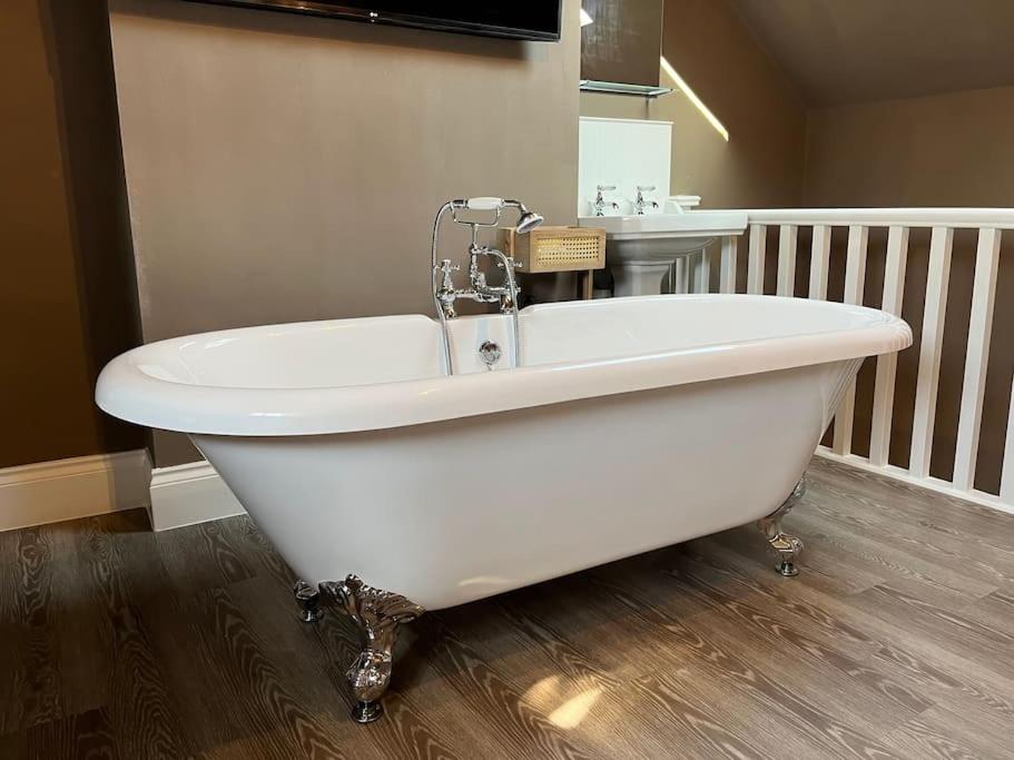 a white bath tub in a bathroom with a sink at Cosy two bed townhouse in Centre of C.Norton in Chipping Norton
