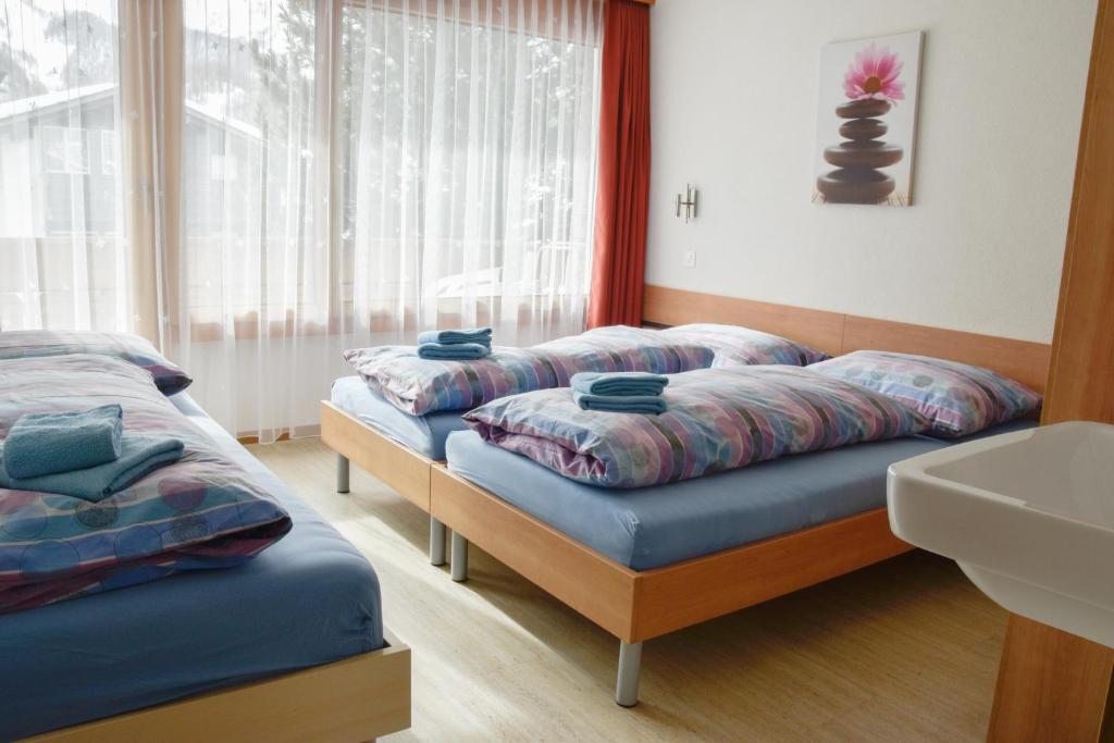 una camera con due letti con cuscini sopra di Heidi a Saas-Fee