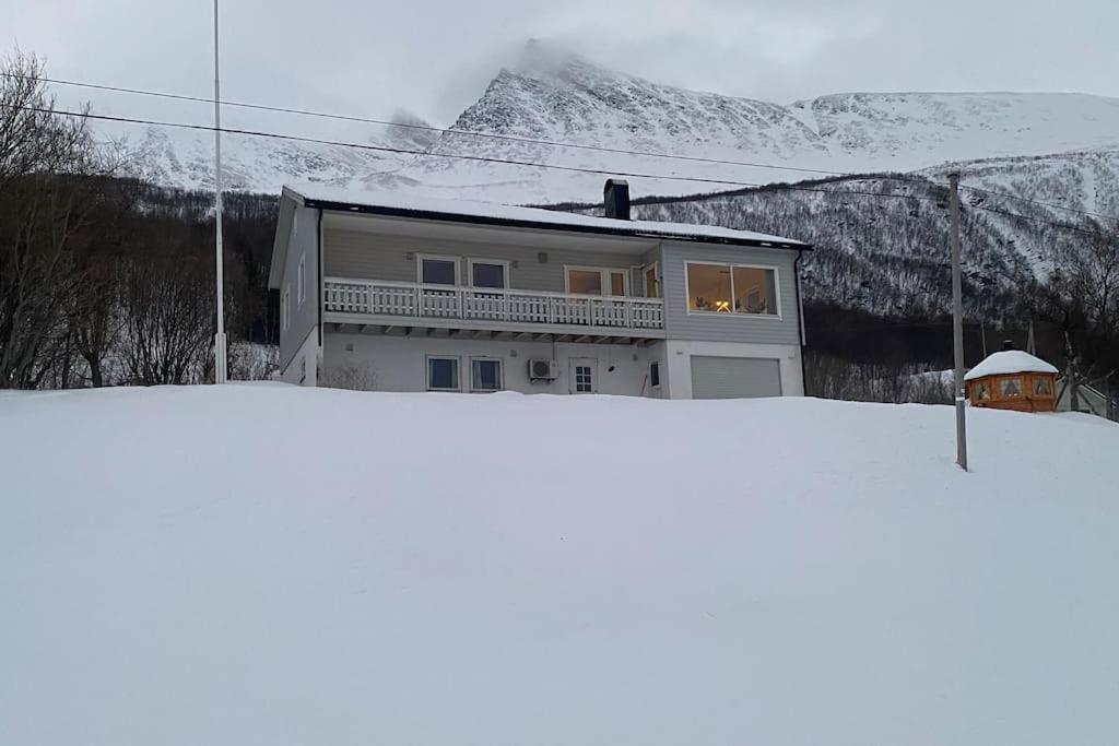 een huis bovenop een met sneeuw bedekte berg bij Skogstad Ferie og fritid in Tromsø