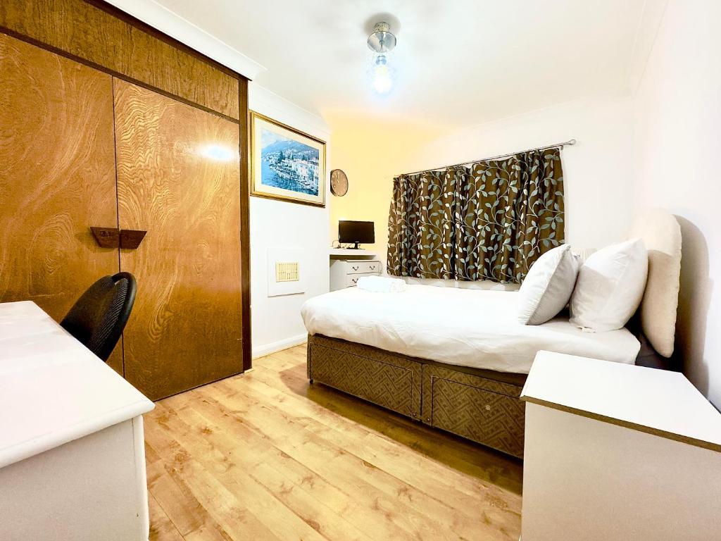 a small bedroom with a bed and a wooden door at Lime Tree House in Heston