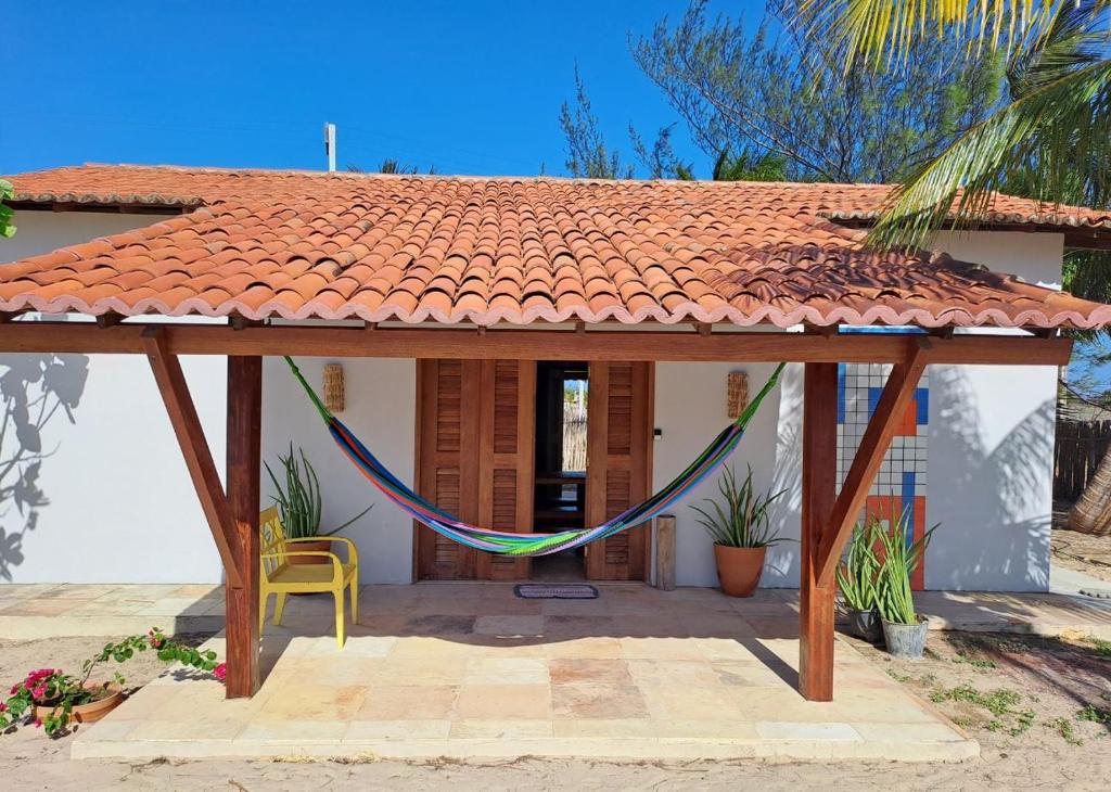ein Haus mit einer Hängematte davor in der Unterkunft Casa Sofia - Macapá Paradise in Luis Correia