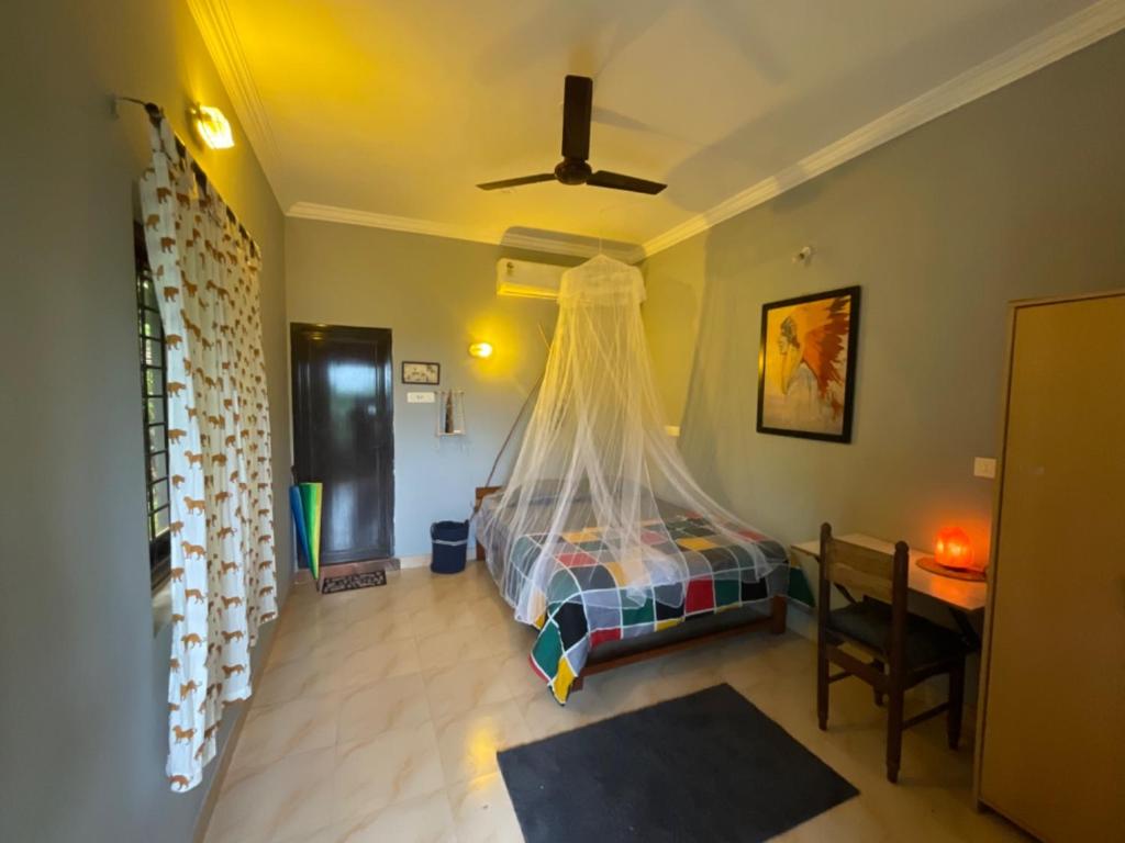 a bedroom with a bed with a mosquito net at De CaveMan Goa A Jungle Retreat in Arambol