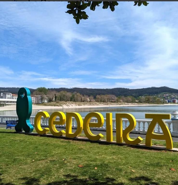 a large sign that reads cedril next to a body of water at Apartamento Alentía in Cedeira