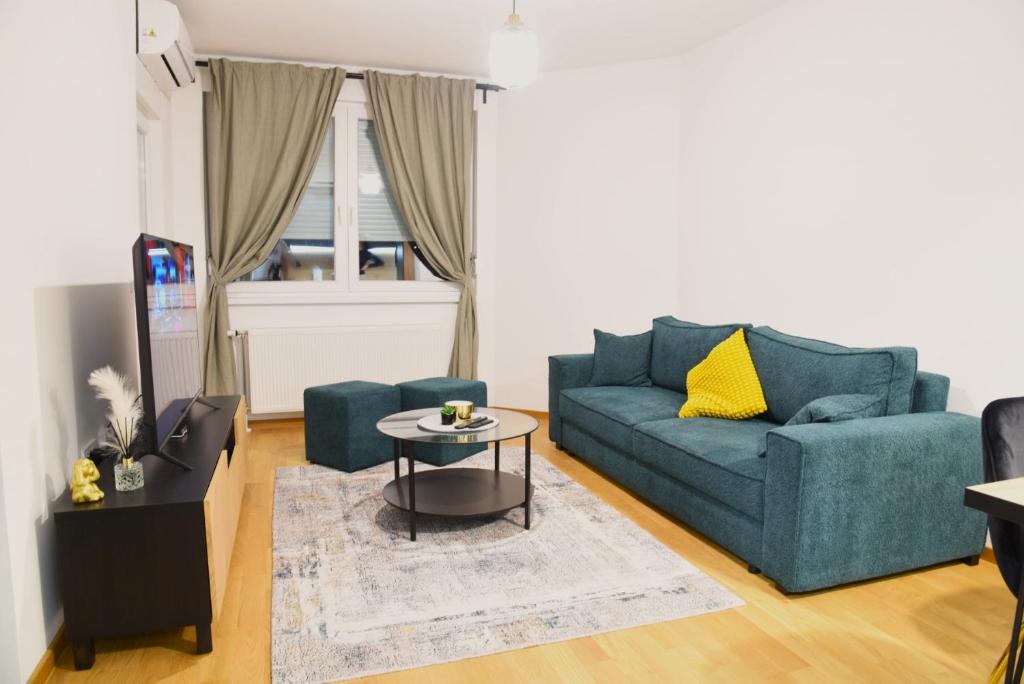 a living room with a blue couch and a table at Apartman Besta in Banja Luka