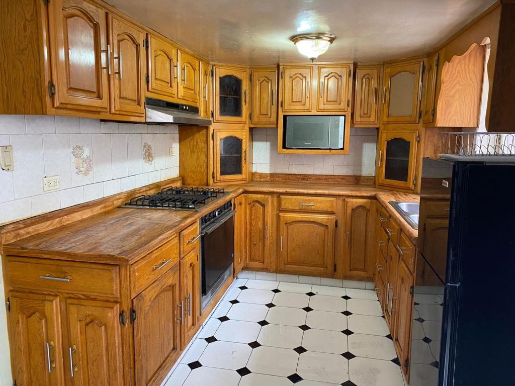 cocina con armarios de madera y horno con fogones en Departamento céntrico casa Paulora, en Hidalgo del Parral