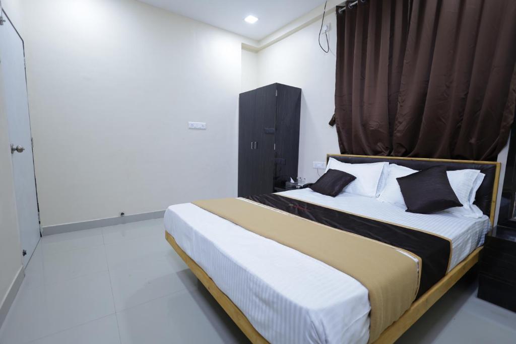 una camera da letto con un grande letto con una tenda marrone di Hotel SolStay Inn Residency a Thane