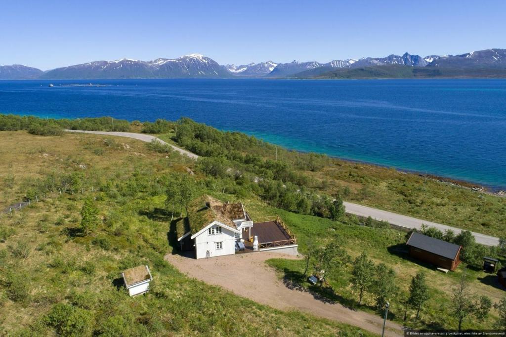 an aerial view of a house on a hill next to the water at Centrally Located Cabin by the Sea - Sortland in Sortland