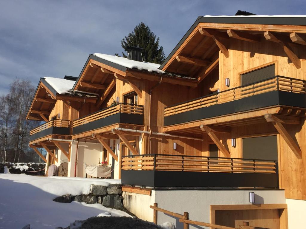 a large wooden house with snow on the ground at Appartement neuf dans chalet idéalement situé, 5 couchages Prestations de qualité in Samoëns