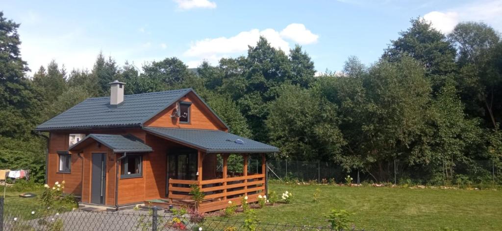 una cabina in un campo con alberi sullo sfondo di Dom nad wodospadem a Kletno