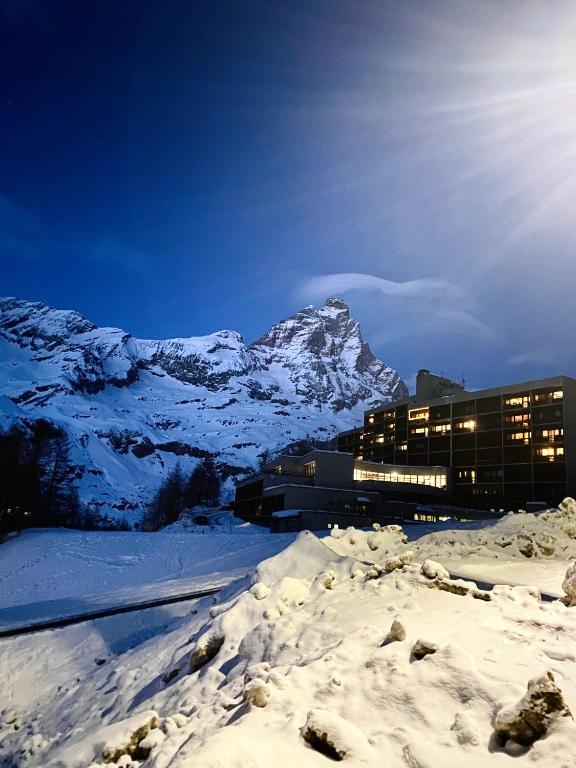 a building in the snow with a mountain in the background at Ski paradise - Cielo alto Cervinia in Breuil-Cervinia
