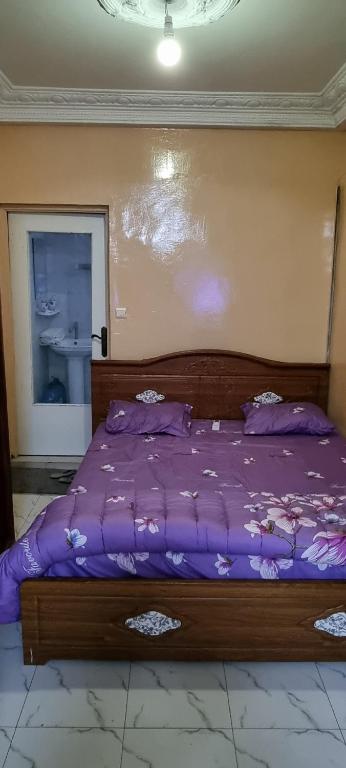 1 cama con edredón morado en un dormitorio en Villa Lumière, en Dakar