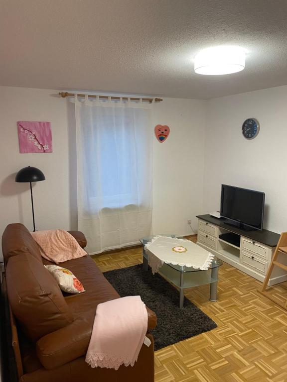 een woonkamer met een bank en een tv bij Ferienwohnung Alex in Nusplingen