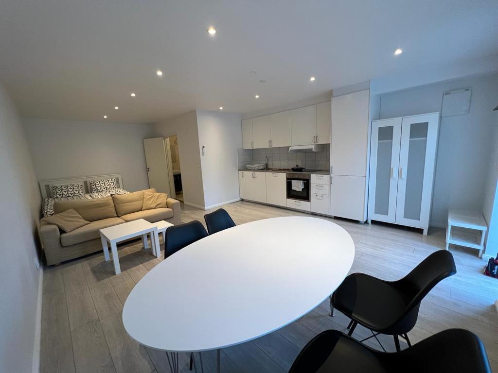 ein Wohnzimmer mit einem weißen Tisch und Stühlen in der Unterkunft Newly furnished apartment close to beach. in Abbekås