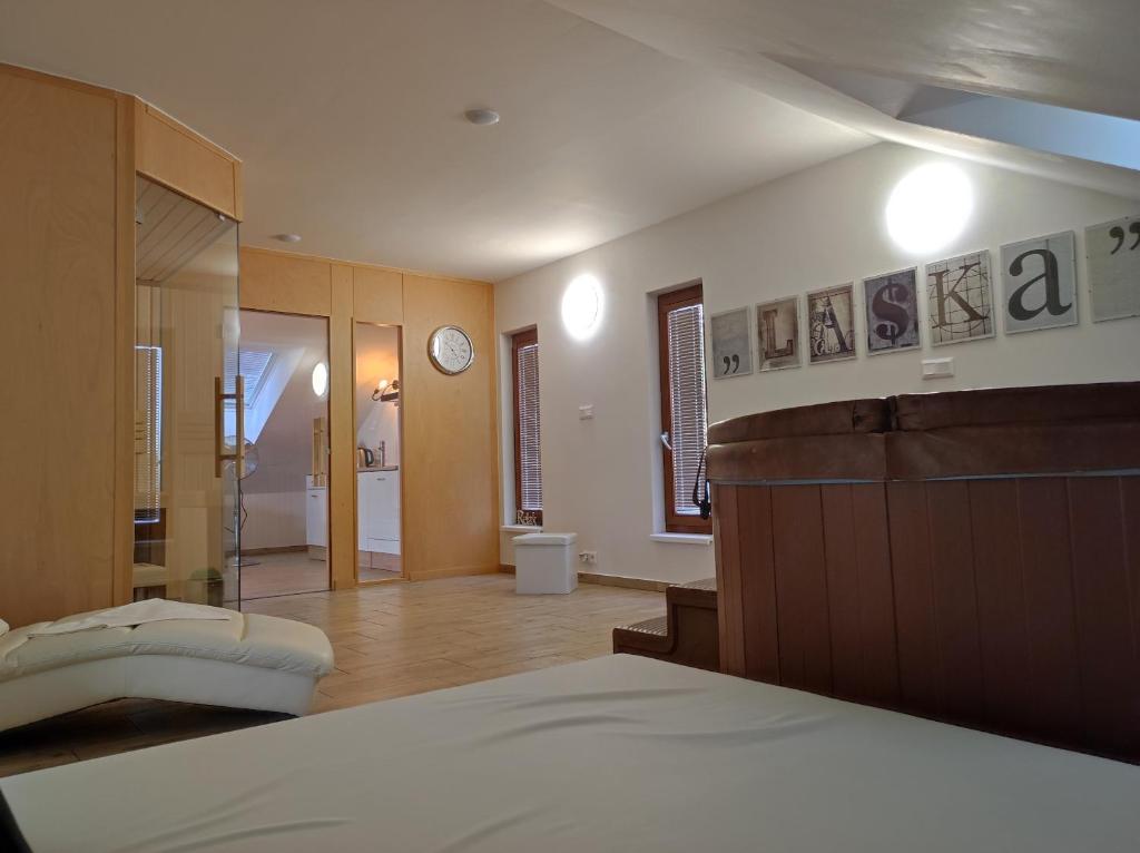a bedroom with a bed and a bathroom with a clock at Wellness apartmán s vířivkou a saunou in Plzeň