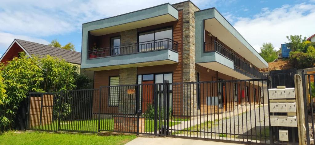 une maison avec un portail en fer et une clôture dans l'établissement Moderno departamento con balcón en IslaTeja, Valdivia, à Valdivia